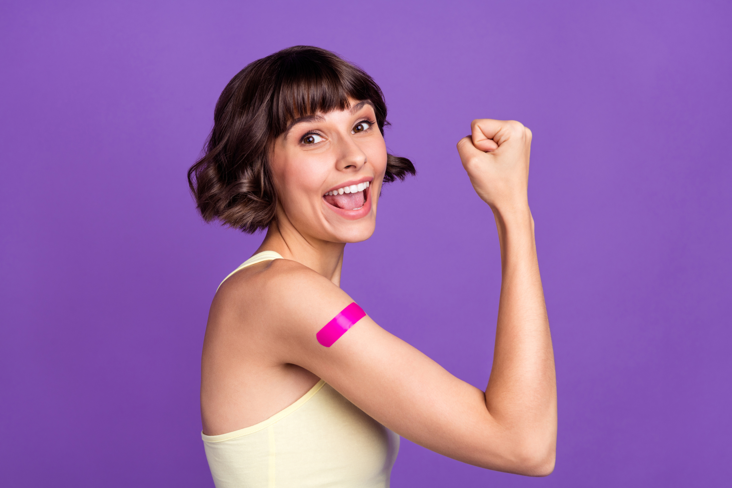 Photo of cheerful happy positive young woman vaccine prevention winner isolated on violet color background Glücklicher Impfling