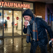 Mann mit Taschentuch in Notaufnahme, um Krankschreibung zu erhalten