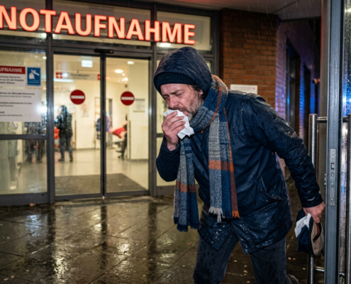 Mann mit Taschentuch in Notaufnahme, um Krankschreibung zu erhalten
